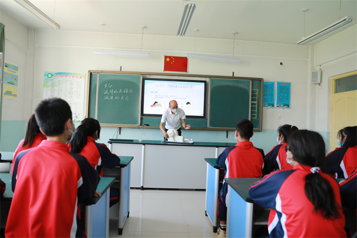 bbe1625f1cc054a32fc9a8a788bdb508.jpg 图二:在新和县第二中学,老师正在为学生讲解飞机起飞原理。(李旭 摄).jpg