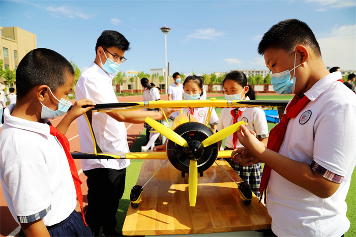 e7356666c12cce8ee0b2492caafa5dd4.jpg 图一:“你们知道模型飞机的构造和飞行原理么?”老师的细致讲解,勾起了学生的学习兴趣。(戴冬 摄).jpg