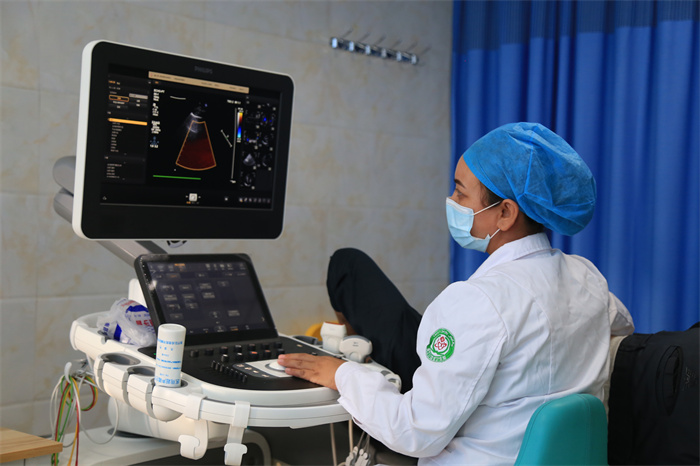 图八:阿瓦提县人民医院超声科医生认真为患者检查身体,边探查,边思考